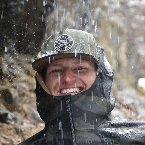 Bruce CTRL smiling in the rain, hood up in the Colorado outdoors